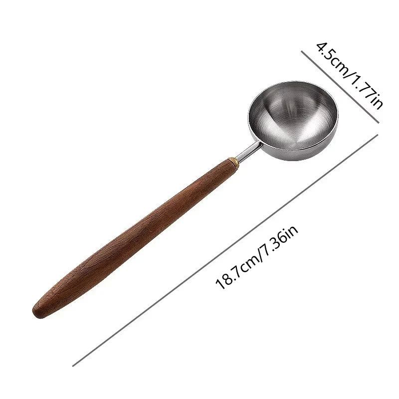 Stainless steel 25ml coffee scoop with wooden handle for precise measuring.