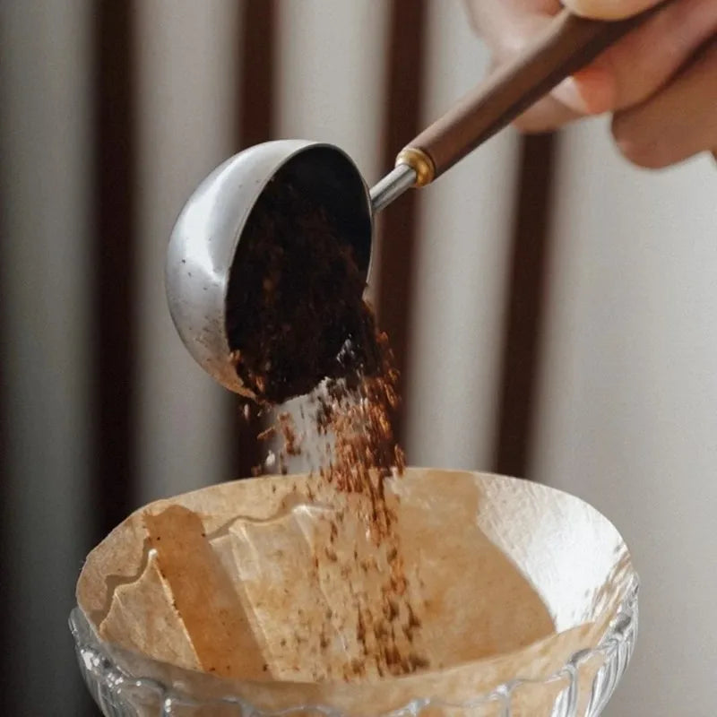 Stainless steel 25ml coffee scoop with wooden handle.