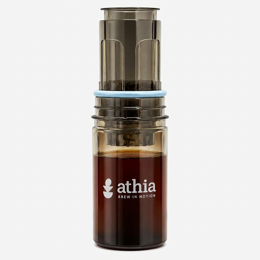 ATHIA portable coffee brewer centered upright on white with soft warm studio lighting and a subtle shadow