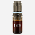 ATHIA portable coffee brewer centered upright on white with soft warm studio lighting and a subtle shadow