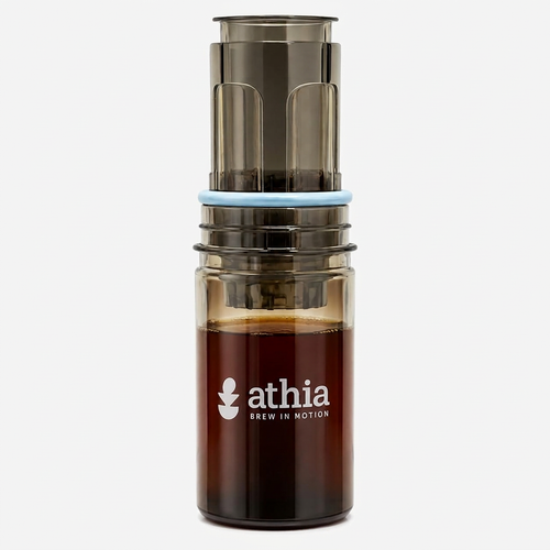 ATHIA portable coffee brewer centered upright on white with soft warm studio lighting and a subtle shadow