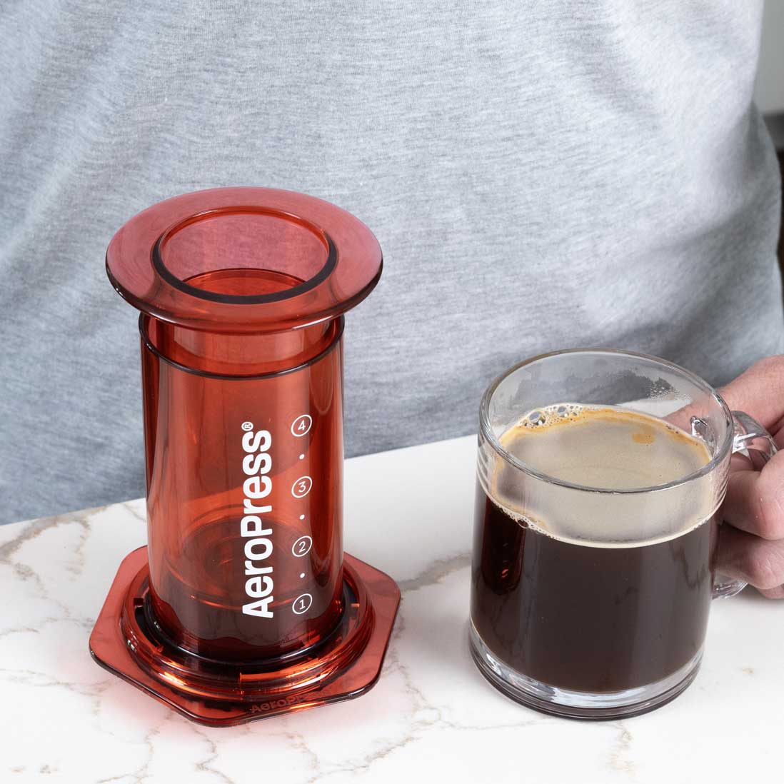 Red version of the 10 oz AeroPress Clear Coffee Maker for manual brewing.