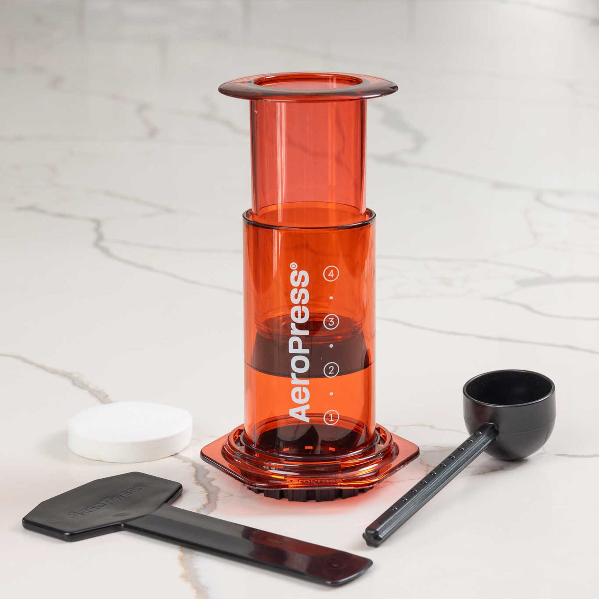 Red version of the 10 oz AeroPress Clear Coffee Maker for manual brewing.