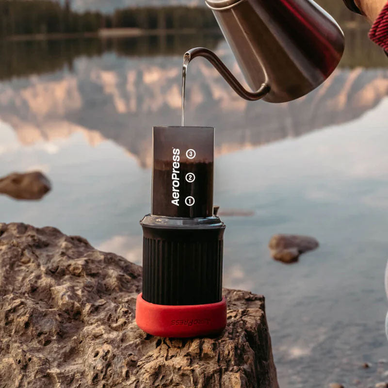 AeroPress Go Travel Coffee Maker in black with mug and lid.
