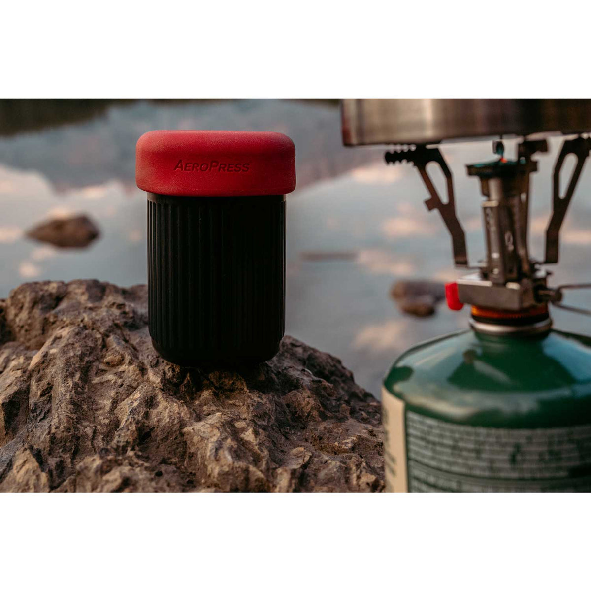 AeroPress Go Travel Coffee Maker in black with mug and lid.