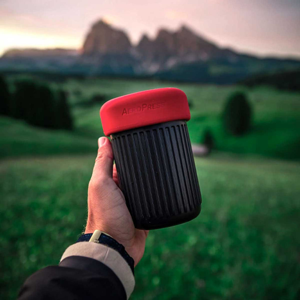 AeroPress Go Travel Coffee Maker in black with mug and lid.