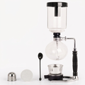 YUCHENGTECH glass siphon coffee maker centered upright on bright white with soft warm lighting and subtle shadows